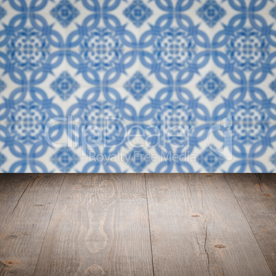 Wood table top and blur vintage ceramic tile pattern wall