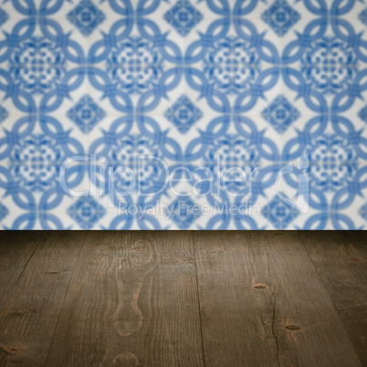 Wood table top and blur vintage ceramic tile pattern wall