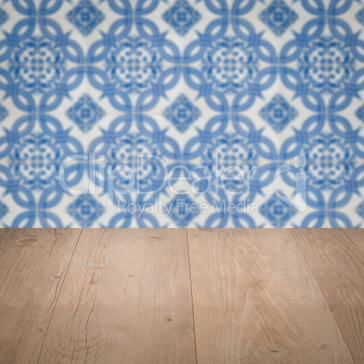 Wood table top and blur vintage ceramic tile pattern wall