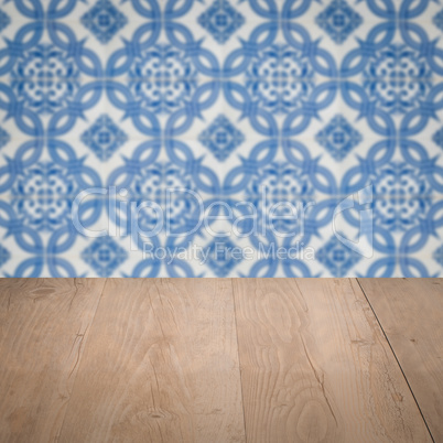 Wood table top and blur vintage ceramic tile pattern wall