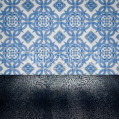 Wood table top and blur vintage ceramic tile pattern wall