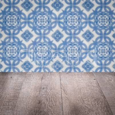 Wood table top and blur vintage ceramic tile pattern wall