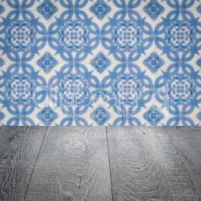 Wood table top and blur vintage ceramic tile pattern wall