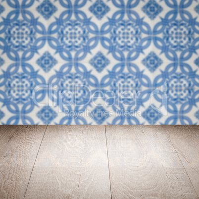 Wood table top and blur vintage ceramic tile pattern wall