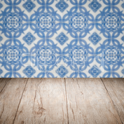 Wood table top and blur vintage ceramic tile pattern wall Wood table top and blur vintage ceramic tile pattern wall
