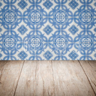 Wood table top and blur vintage ceramic tile pattern wall