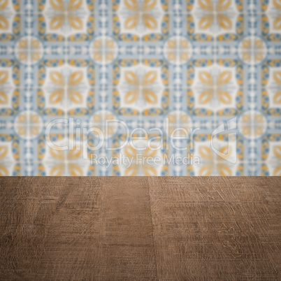 Wood table top and blur vintage ceramic tile pattern wall