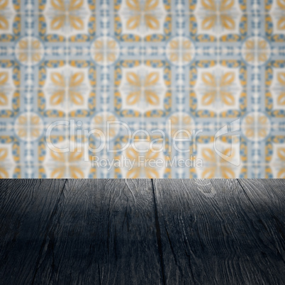 Wood table top and blur vintage ceramic tile pattern wall