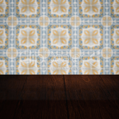 Wood table top and blur vintage ceramic tile pattern wall