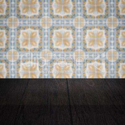 Wood table top and blur vintage ceramic tile pattern wall