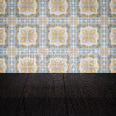 Wood table top and blur vintage ceramic tile pattern wall