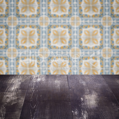 Wood table top and blur vintage ceramic tile pattern wall