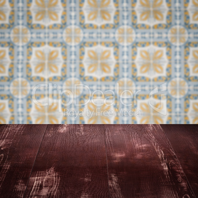 Wood table top and blur vintage ceramic tile pattern wall