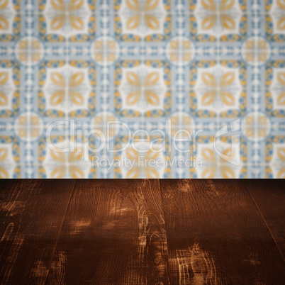 Wood table top and blur vintage ceramic tile pattern wall Wood table top and blur vintage ceramic tile pattern wall
