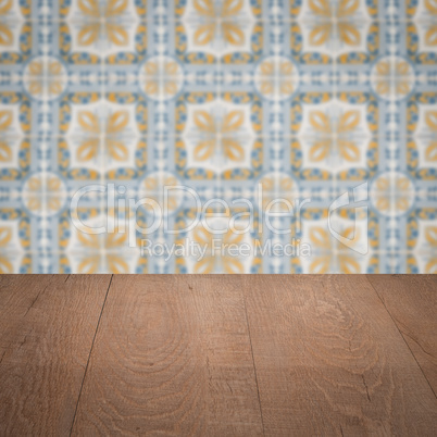 Wood table top and blur vintage ceramic tile pattern wall