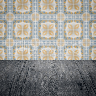 Wood table top and blur vintage ceramic tile pattern wall