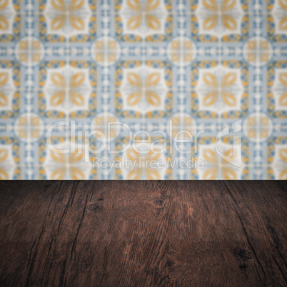 Wood table top and blur vintage ceramic tile pattern wall