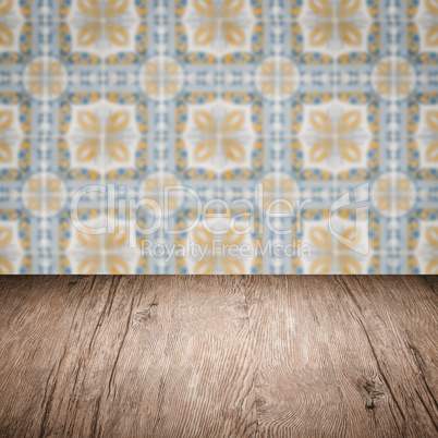 Wood table top and blur vintage ceramic tile pattern wall