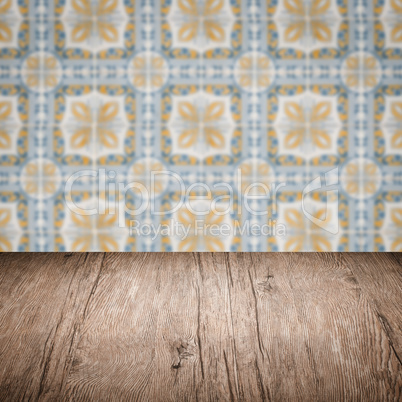 Wood table top and blur vintage ceramic tile pattern wall