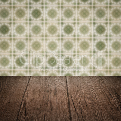 Wood table top and blur vintage ceramic tile pattern wall