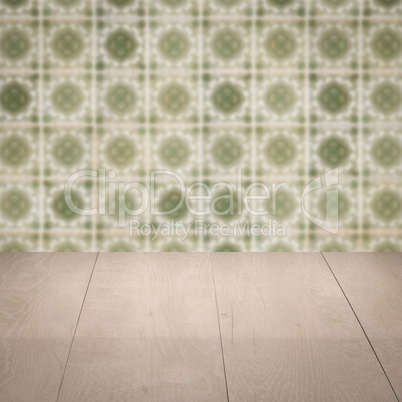 Wood table top and blur vintage ceramic tile pattern wall