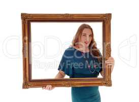 Woman holding and looking trough picture frame.