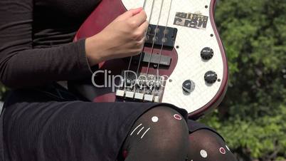 Young Female Strumming Electric Guitar