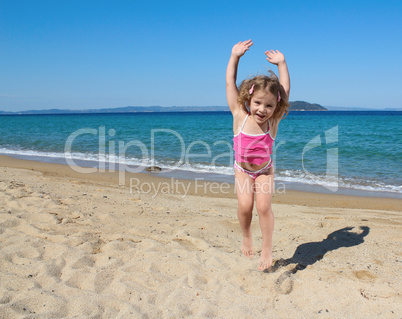 happy little girl jumping on the beach