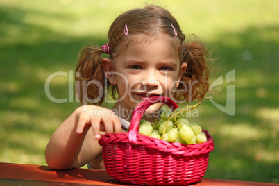 little girl eat grape