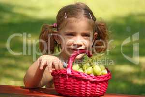 little girl eat grape