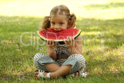 little girl eat watermelon in park