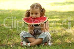 little girl eat watermelon in park