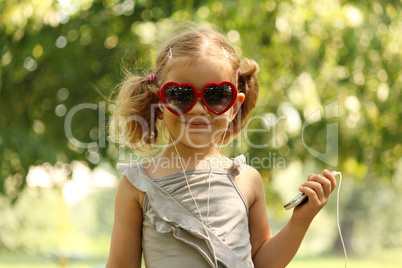 little girl with sunglasses listening music