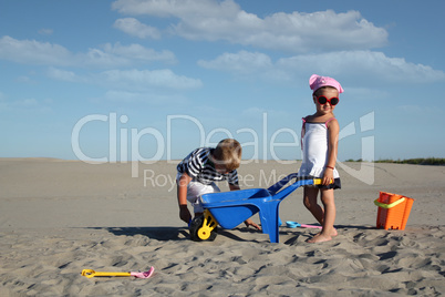 little girl and little boy playing in sand