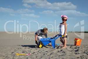 little girl and little boy playing in sand