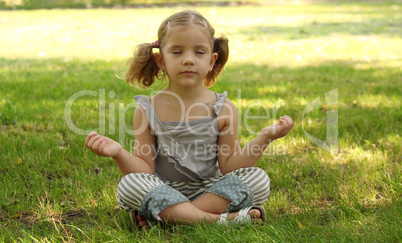 little girl meditating in park