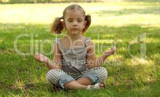 little girl meditating in park