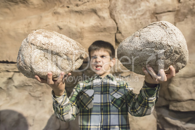 Strong child holds heavy stone