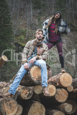 Young woman and men on wood logs