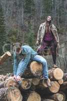 Young woman and men on wood logs