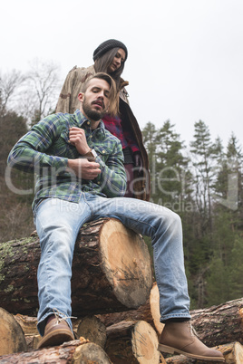 Young woman and men on wood logs