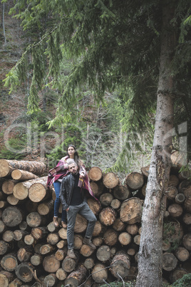 Young woman and men on wood logs