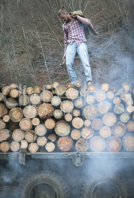 Young man on vintage truck with logs