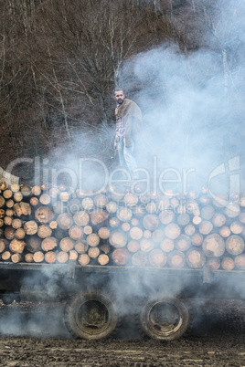 Young man on vintage truck with logs