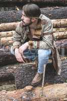 Young men on logs in the forest.