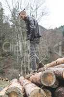 Young men on logs in the forest.