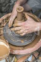 Potter makes clay bottle