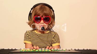 little girl with sunglasses play music