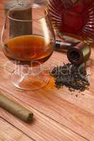 Cognac and tobacco pipe on a wooden table