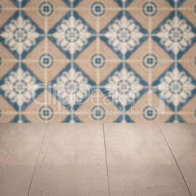 Wood table top and blur vintage ceramic tile pattern wall